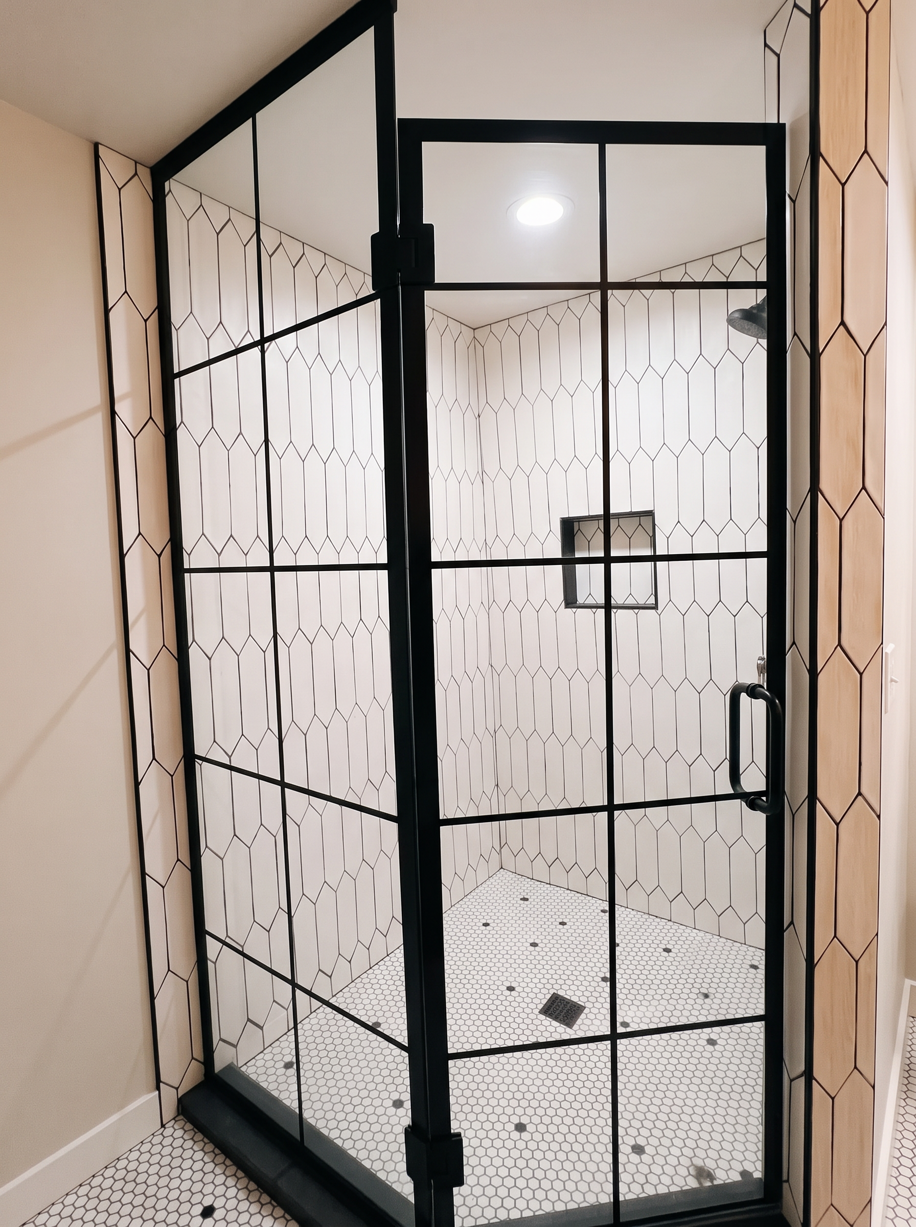 A tiled guest shower in soft light