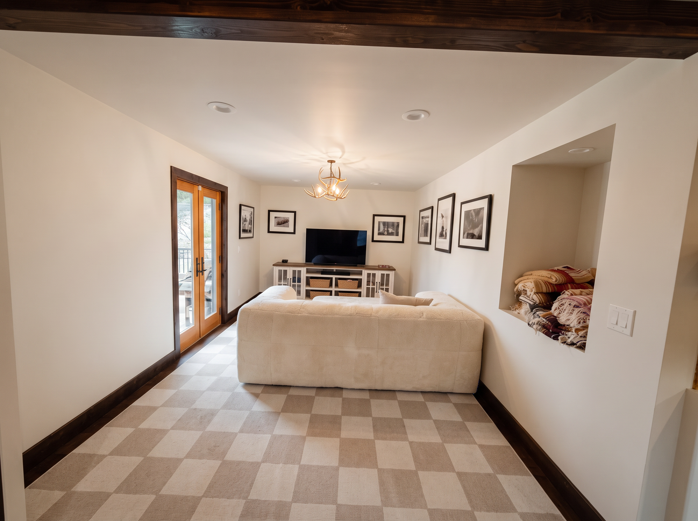 The family room with a wood stove, deep sofas, and windows onto the meadow